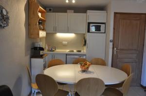 a kitchen with a table and chairs in a kitchen at Appartement cosy Peisey Les Arcs 6-8 pers - piscine sauna - en face des pistes in Peisey-Nancroix
