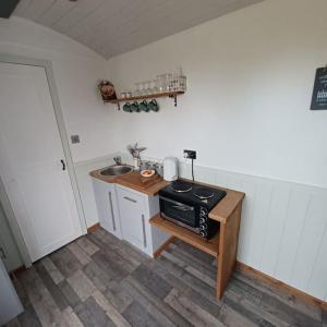 a small kitchen with a sink and a stove at The Shepherd's Delight in Rushton Spencer