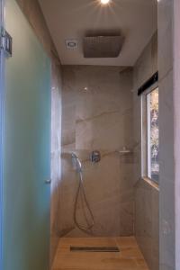 HOM54 Luxury Suites في مدينة هيراكيلون: حمام مع دش مع باب زجاجي