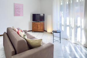 a living room with a couch and a flat screen tv at ANDREA Apartment in Levanto