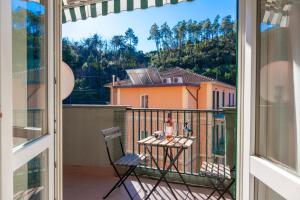balkon ze stołem i krzesłami oraz widokiem na dom w obiekcie ANDREA Apartment w mieście Levanto