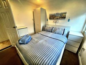 a small bedroom with a bed with a striped mattress at Wight Waves Holidays in Sandown