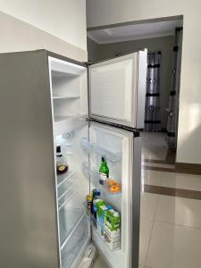 an empty refrigerator with its door open in a kitchen at Mtei Safaris Hostel in Arusha
