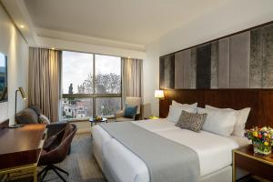 a hotel room with a large bed and a desk and a desk at Olive Tree Hotel in Jerusalem