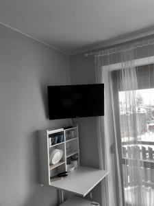 a flat screen tv hanging on a wall next to a window at Willa Ewa in Krynica Zdrój