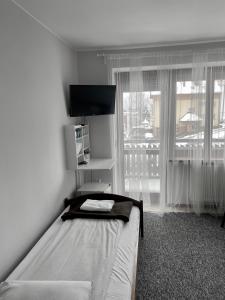 a bedroom with a bed and a large window at Willa Ewa in Krynica Zdrój