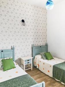 Duas camas num quarto com paredes verdes e brancas em Casa Las Enanitas I - Casa Leo em Fuencaliente de la Palma