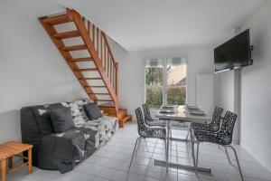 ein Wohnzimmer mit einem Sofa und einem Tisch mit Stühlen in der Unterkunft Maison familiale à 500m de la plage in Piriac-sur-Mer