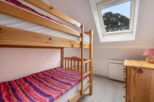 濱海皮里亞克的住宿－Maison familiale à 500m de la plage，一间卧室设有两张双层床和一扇窗户。