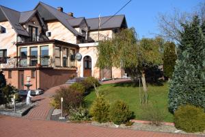 a large house with a landscaping in front of it at Agroturystyka nad Nidą in Włoszczowa