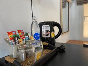 a counter with a coffee maker and a bottle of water at THA PAE SUNG - ท่าแพซุง in Uthai Thani