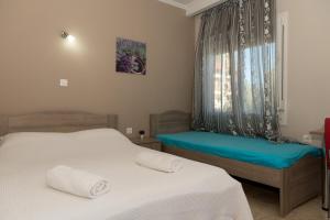 a bedroom with two beds and a window at Tzamtzis Apartments in Keramoti