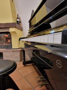 un piano en una sala de estar con chimenea en Agriturismo Garzolé, en Castelfranco Emilia