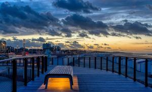 a bench sitting on a boardwalk next to the ocean at La Brise Marine in Calais
