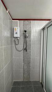 La salle de bains est pourvue d'une douche et de carrelage. dans l'établissement THA PAE SUNG - ท่าแพซุง, à Uthai Thani