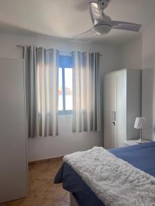 ein Schlafzimmer mit einem Bett und einem Deckenventilator in der Unterkunft Amazing Mountain and Sea Views - Mojon Hills, Isla Plana, Spain in Isla Plana + 25 Fotos