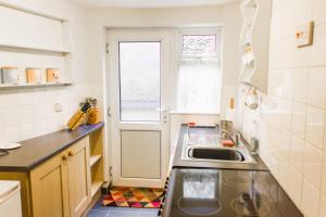 a small kitchen with a sink and a window at Shoemakers Cottage - Norfolk Holiday Properties in Cromer