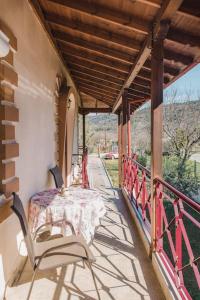 a porch with a table and chairs on a balcony at Ολοκληρη Βιλα in Edessa