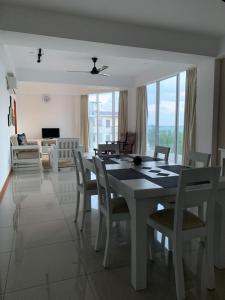 a living room with a dining room table and chairs at Nilaveli Beach Apartment Sri Lanka in Nilaveli