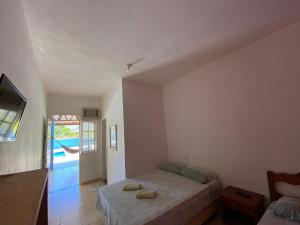 1 dormitorio con 1 cama, TV y ventana en Pousada da Rose, en Prado
