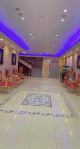 Cette grande chambre est dotée de tables et de chaises ainsi que d'un plafond violet. dans l'établissement فندق كراون نجران, à Najran