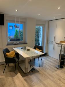 een keuken met een tafel en stoelen in een kamer bij City Apartments am Rhein in Bonn