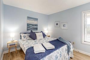 1 dormitorio con 1 cama con 2 toallas en Bammers Beach Spot OS26, en Corolla