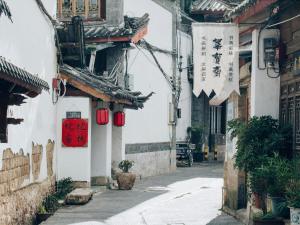 麗江市にあるTuo Tuo Guest Houseの赤い看板のあるアジア都市の路地
