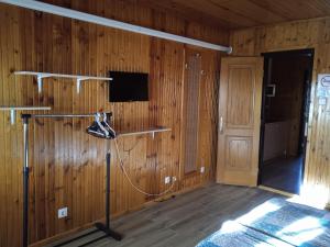 um quarto com uma parede de madeira, uma televisão e um microfone em Málnás Szállás em Dunavarsány