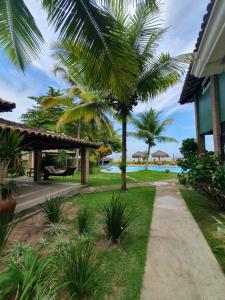 a pathway leading to a resort with palm trees at Pousada Mayon in Cumuruxatiba +69 photos