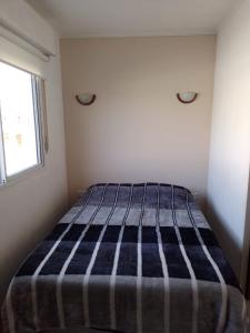 um quarto com uma cama com um cobertor listrado em Leticia y Fabián em Gualeguaychú