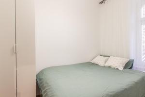 a bedroom with a green bed with two pillows at Golden Apartments/SobF in Katowice