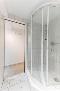 ein weißes Bad mit einer Dusche und einer Glastür in der Unterkunft Altstadt pur im Herzen Marburgs in Marburg an der Lahn