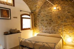 a bedroom with a bed in a stone wall at Appartamenti Antico Frantoio Doria in Imperia