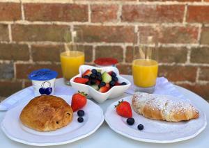 a table with plates of food and fruit and drinks at The Studio in Wisborough Green