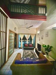ein Wohnzimmer mit einem Sofa und einem TV in der Unterkunft PD SEAVIEW VIP Staycation w WiFi in Kampong Bagan Pinang