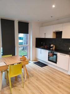 uma cozinha com uma mesa de madeira e cadeiras amarelas em Logement complet à Villeurbanne em Villeurbanne