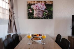 a table with a bowl of fruit and two wine glasses at Stathohouse in Filiatra