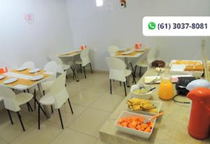 uma sala de jantar com mesas e cadeiras e frutas sobre uma mesa em Hotel Supreme - Pistão Sul - Próximo ao Taguatinga Shopping em Taguatinga