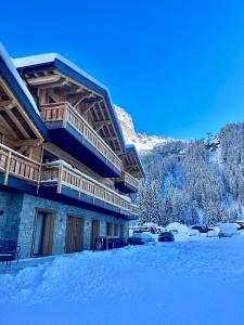 un edificio con nieve en el suelo delante de él en Hameau des Prodains - Résidence en Morzine