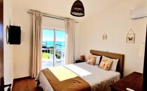 a bedroom with a bed with a view of the ocean at Casa Mar Praia dos Pescadores By ALzira in Albufeira