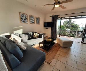 a living room with a couch and a tv at Sunset Condo @ Villas Mayaluum in Cozumel