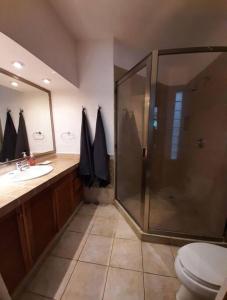 a bathroom with a shower and a toilet and a sink at Sunset Condo @ Villas Mayaluum in Cozumel
