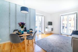 uma sala de jantar com uma mesa e cadeiras numa sala de estar em Blue by the River 1 - elegant two-bedroom in Santos em Lisboa