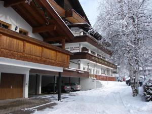 un hotel en la nieve con coches aparcados delante en Seefeld-apartman 3, en Seefeld in Tirol