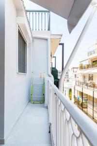 a balcony of a white building with a blue bench at A bright Nest in the heart of Plaka in Athens