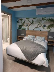 a bedroom with a large bed with a painting on the wall at Hostal Platerías in León