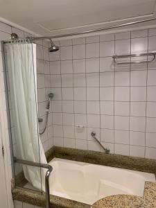 La salle de bains est pourvue d'une douche et d'une baignoire. dans l'établissement Studio no Jurerê Beach Village - Pé na areia, à Florianópolis