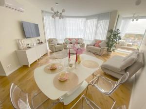 a living room with a white table and chairs at Snieguolės apartamentai in Palanga
