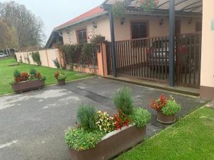 a house with potted plants in front of a driveway at Sobe Glavaš in Garešnica